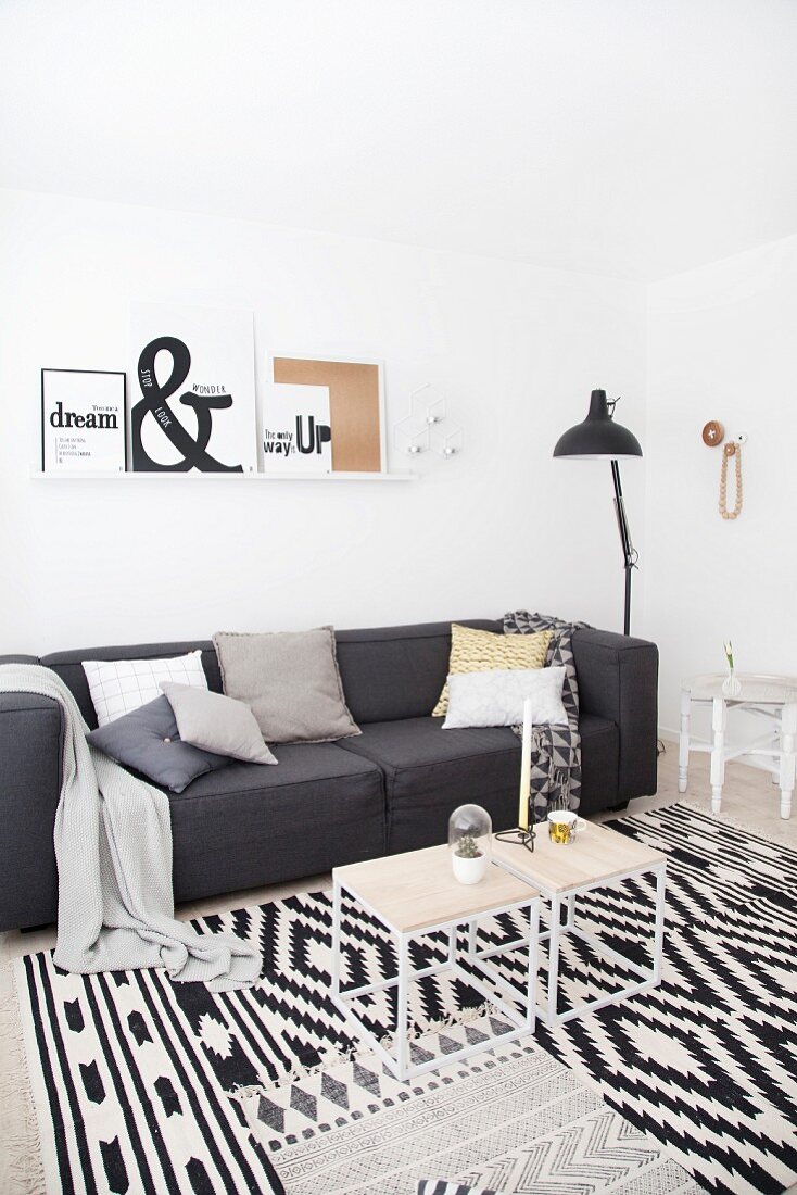 Anthrazitfarbene Couch in schwarz-weißem, modernem Wohnzimmer