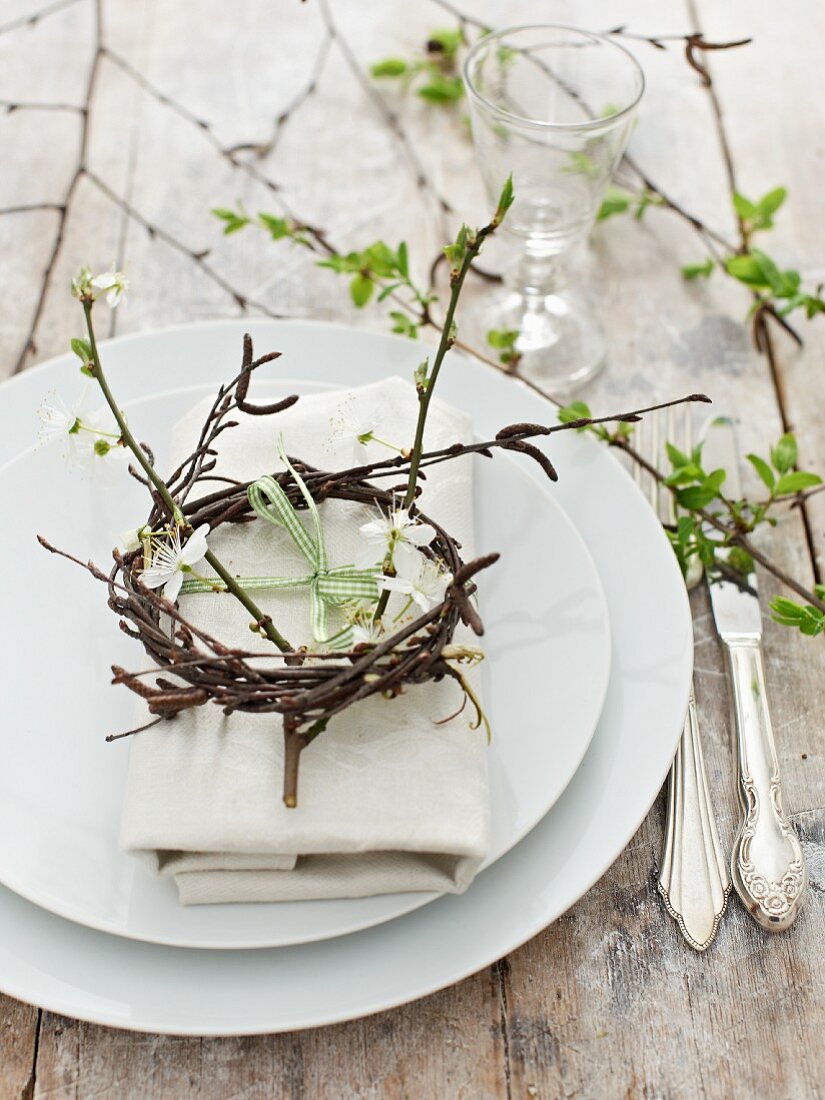 Spring place setting decorated with flowering twigs and small wreath