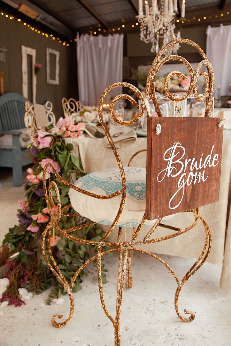 Vintage chair made from rusty, curved metal decorated for wedding