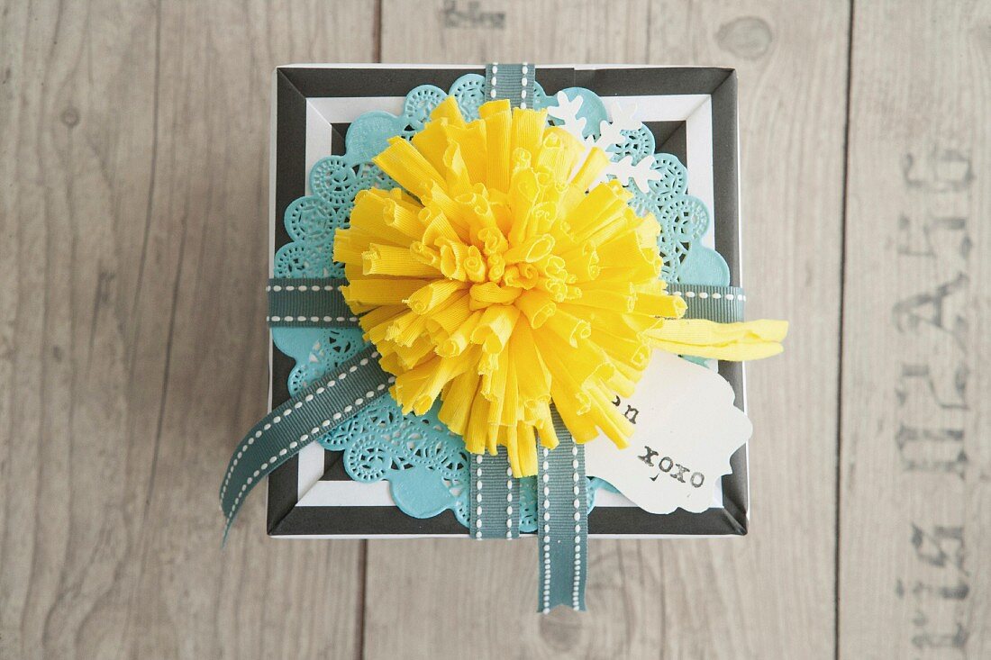 Yellow fabric pompom decorating wrapped gift