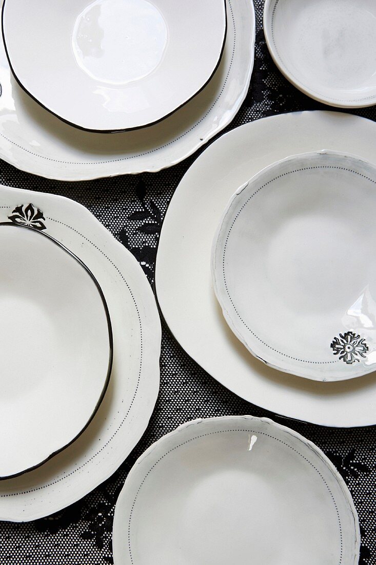 Arrangement von weißen Tellern mit schwarzem Dekor