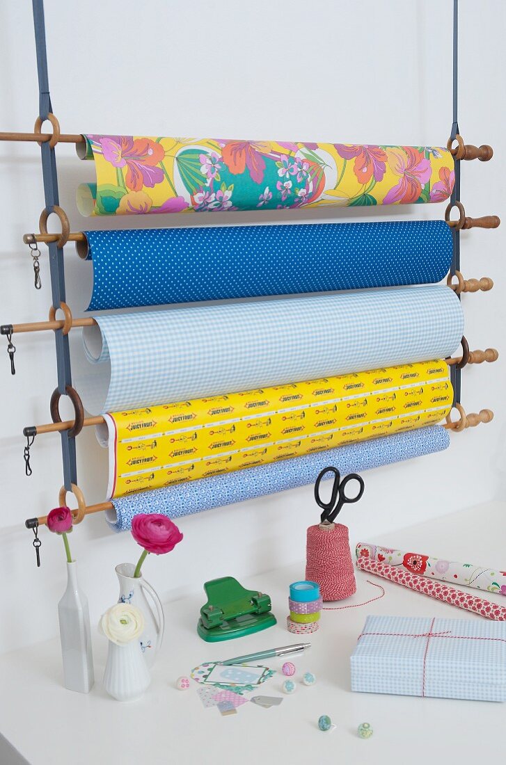Gift wrap rack made from curtain rods and rings held in cotton loops