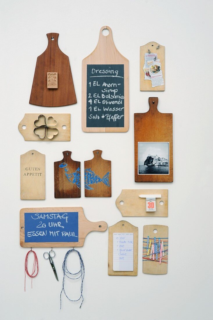 Noteboard arrangement with ornamental elements and memos written on upcycled chopping boards