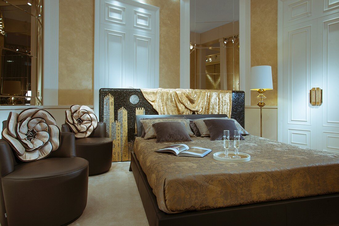 Double bed next to brown, designer leather armchairs, tall interior doors, and structured, gold stucco lustro walls