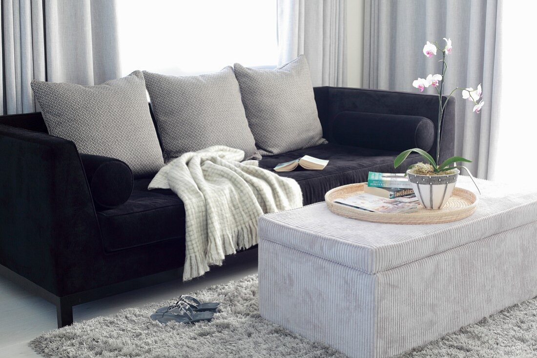 Elegantes Sofa mit schwarzem Samtbezug, gepolsterter Couchtisch mit Cordsamt bezogen