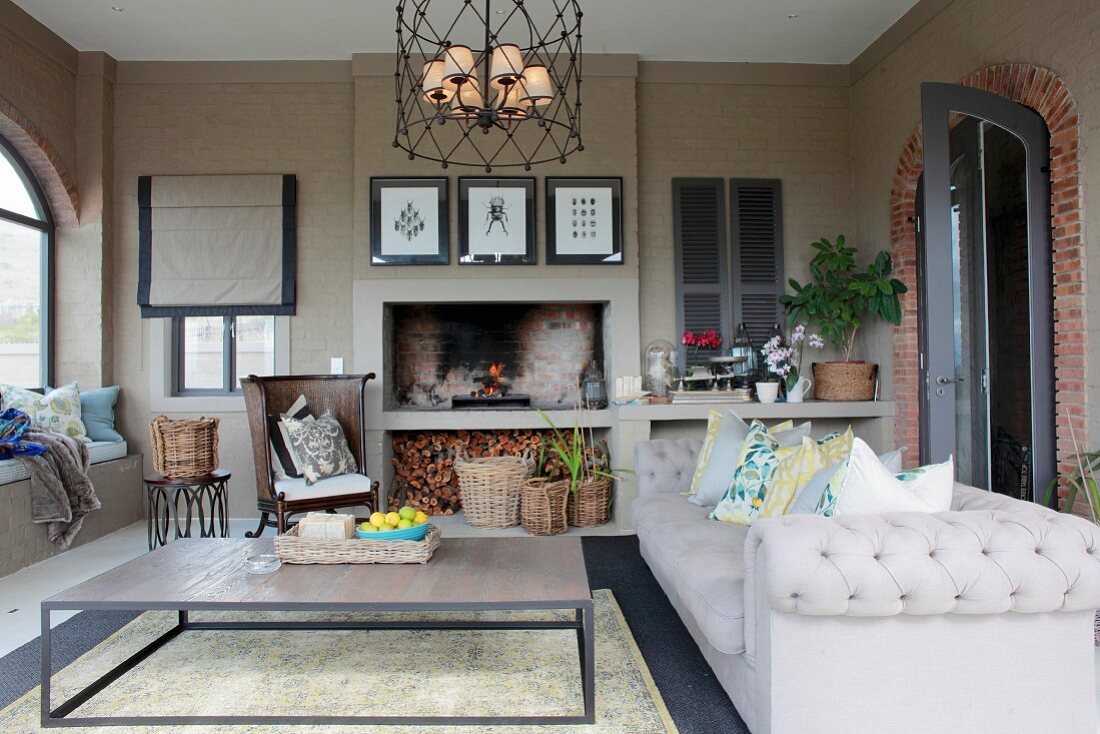 Grey sofa and coffee table on loggia with fireplace