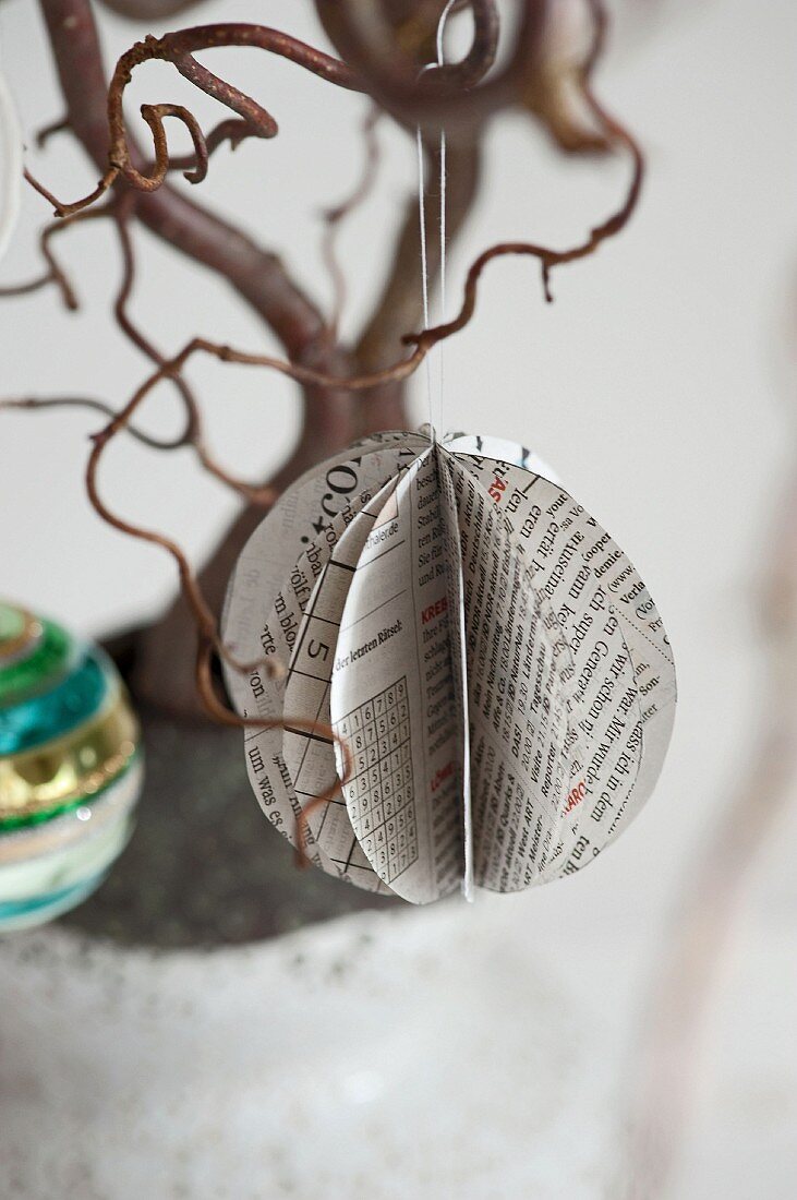 Fanned newspaper decoration hanging from tree