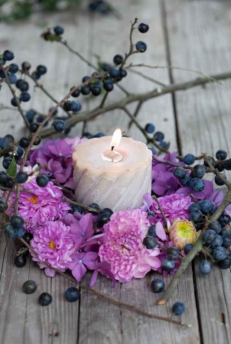 Kerze mit herbstlichem Kranz aus Pompondahlien, Hortensien & Schlehenbeeren