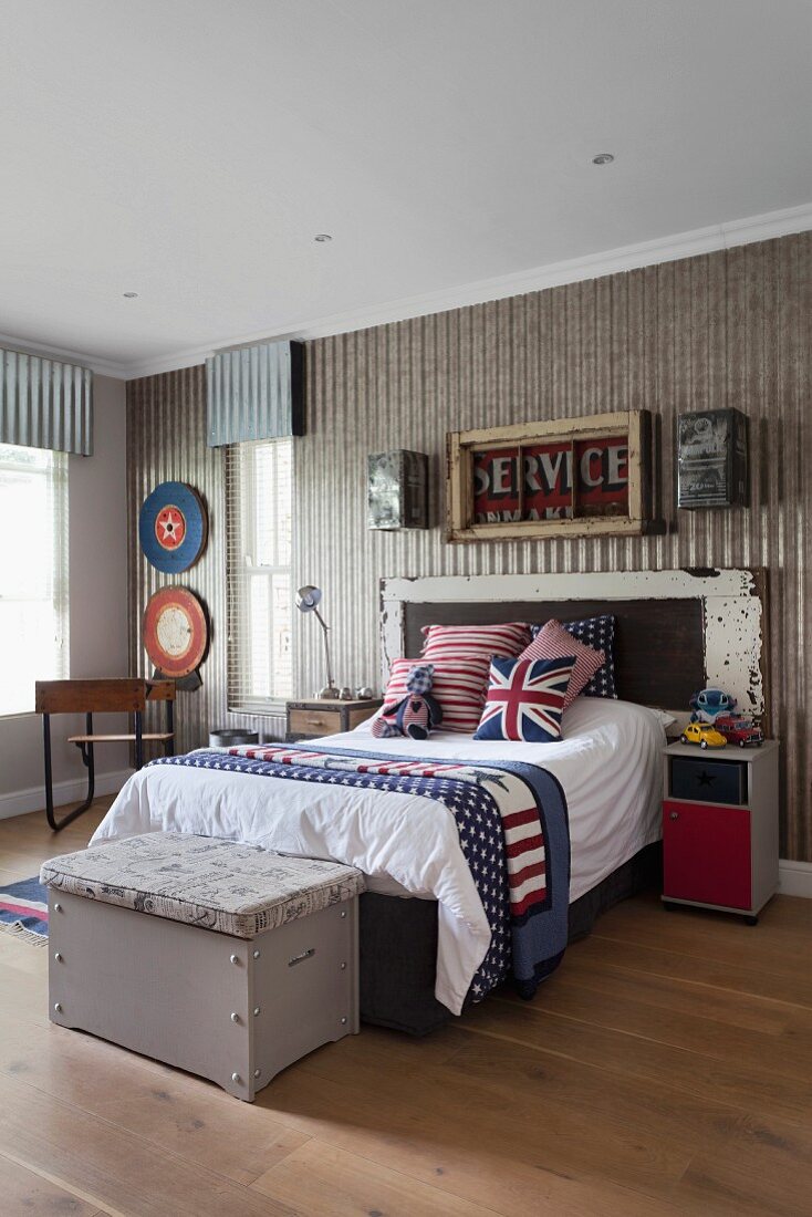 Vintage Jugendzimmer mit Bett und drapierte Kissen, mit englischem Flaggen Motiv, an Bettende alte Holztruhe
