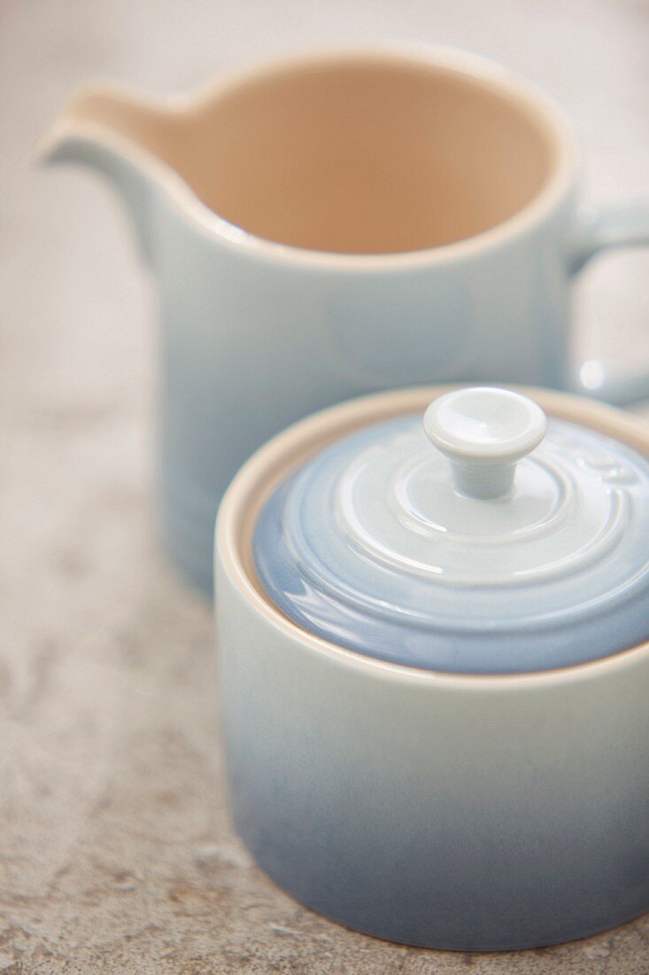 Zuckerdose mit Deckel und passendes Milchkännchen aus pastellblauer Keramik mit Farbverlauf