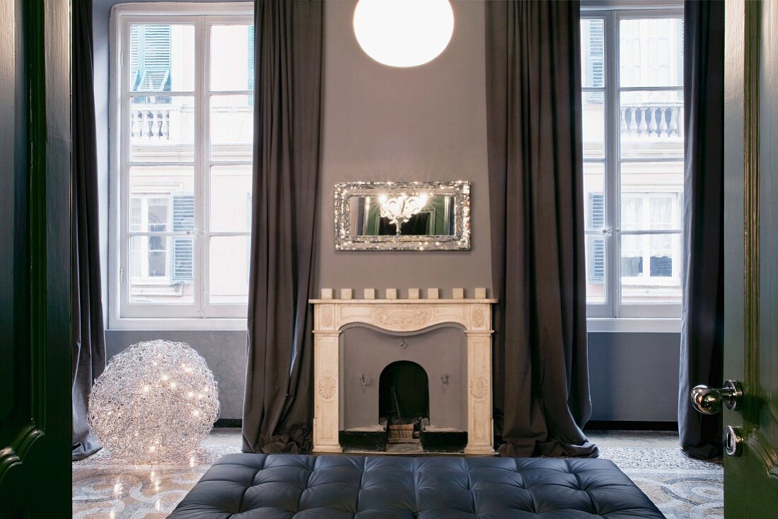 Elegant old room with open fireplace between two mullion windows