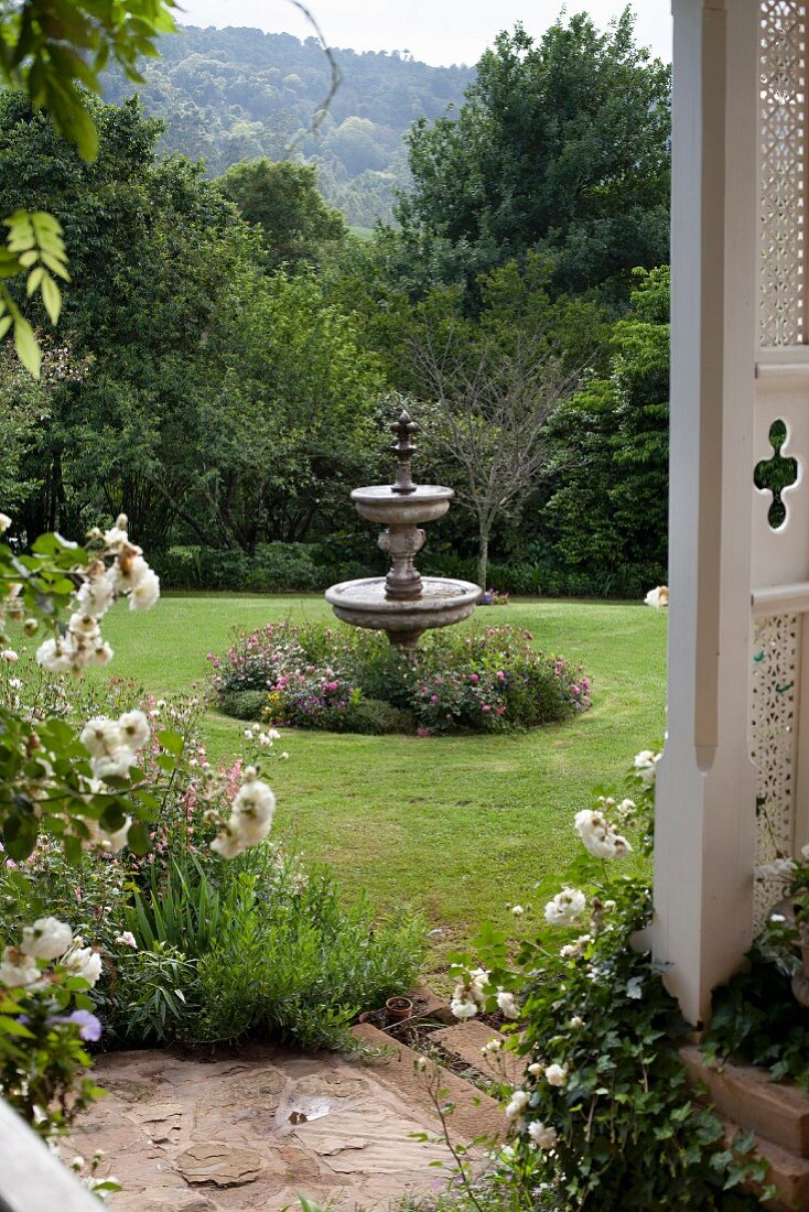 Blick auf Springbrunnen aus Stein in weitläufigem Garten