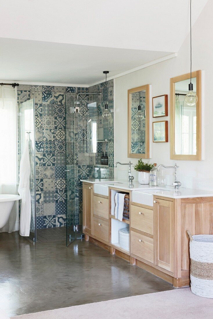 Washstand with vintage-style taps and ornamental tiles in shower area in bathroom
