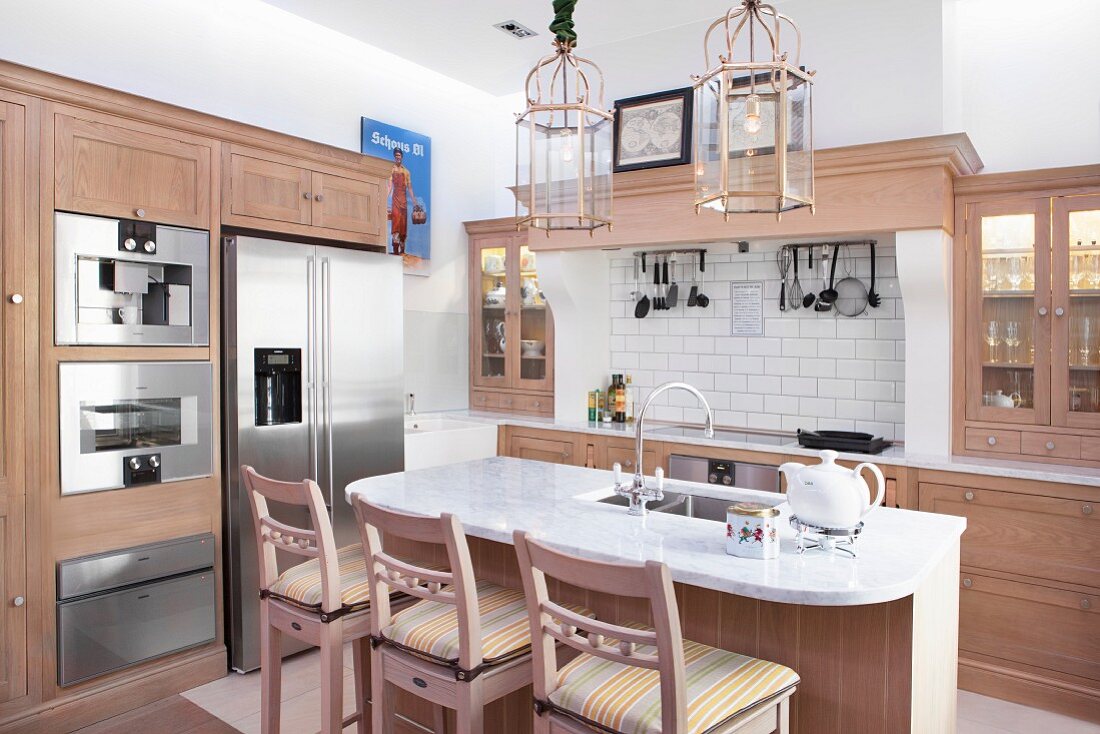 Frühstückstheke und Barhocker in offener Küche aus hellem Holz in modernem Landhausstil