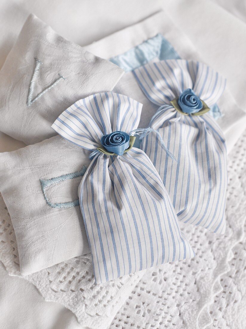 Fabric, scented sachets decorated with satin flowers and embroidered with initials