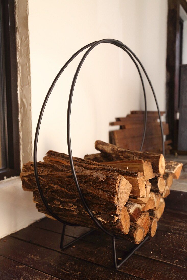 Delicate log rack with curved metal frame