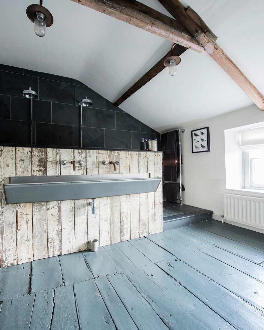 Dachraum mit puristischer Waschrinne an Vintage-Bretterwand und offenem Duschbereich