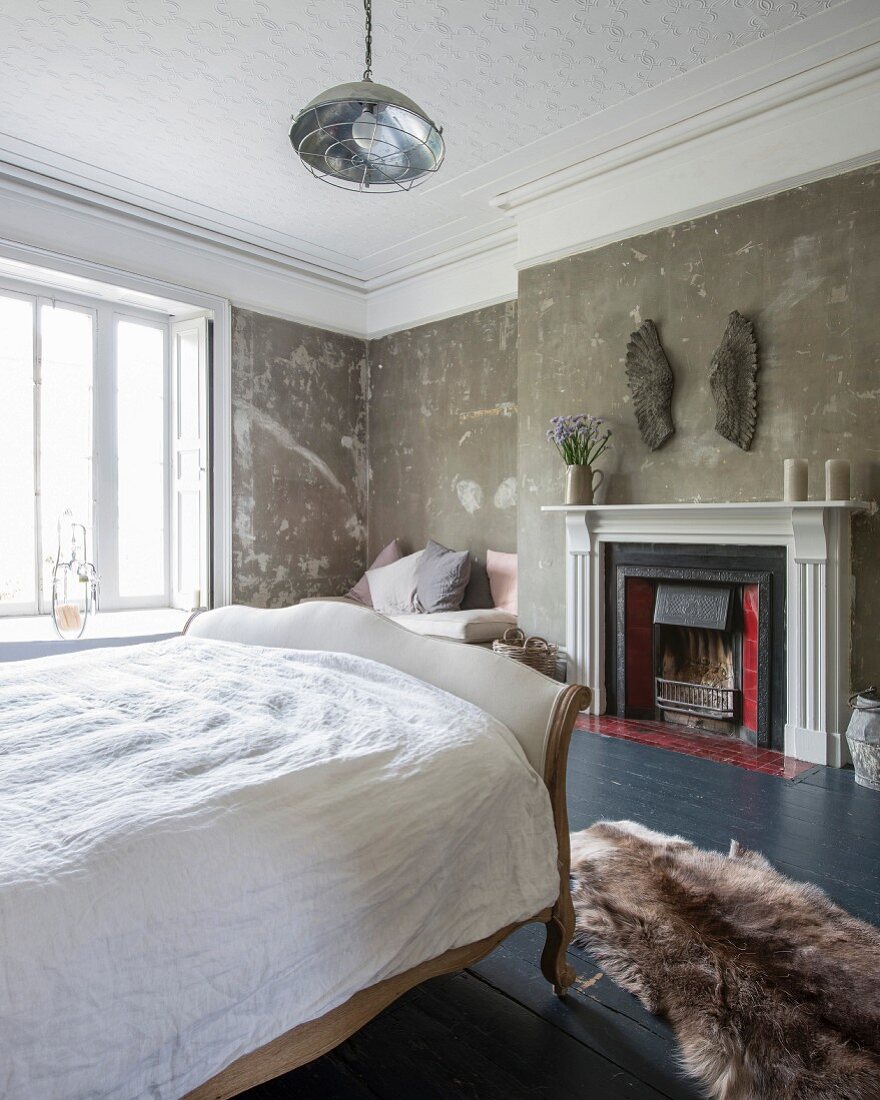 Schlittenbett in Schlafraum eines Landhauses mit Vintage-Farbpatina auf Wänden