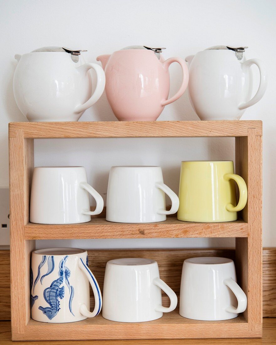 Retro teapots and mugs on wooden shelves
