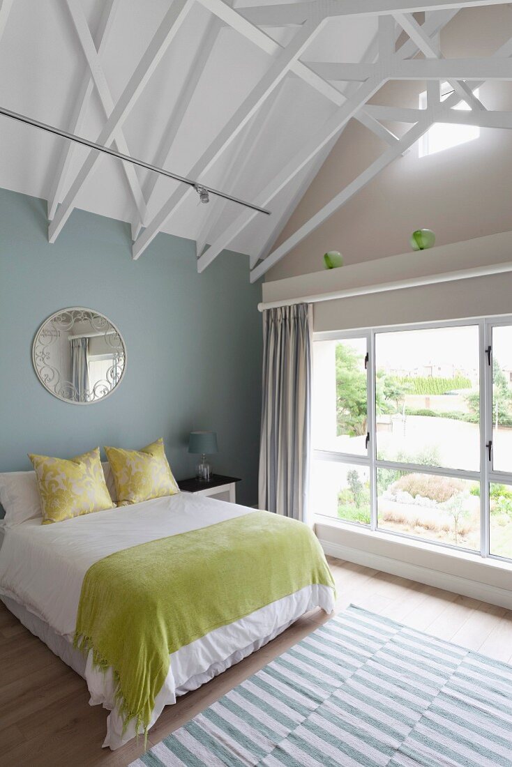 Schlafzimmer in modernem Dachgeschoss mit sichtbarer Dachstuhlkonstruktion weiss lackiert