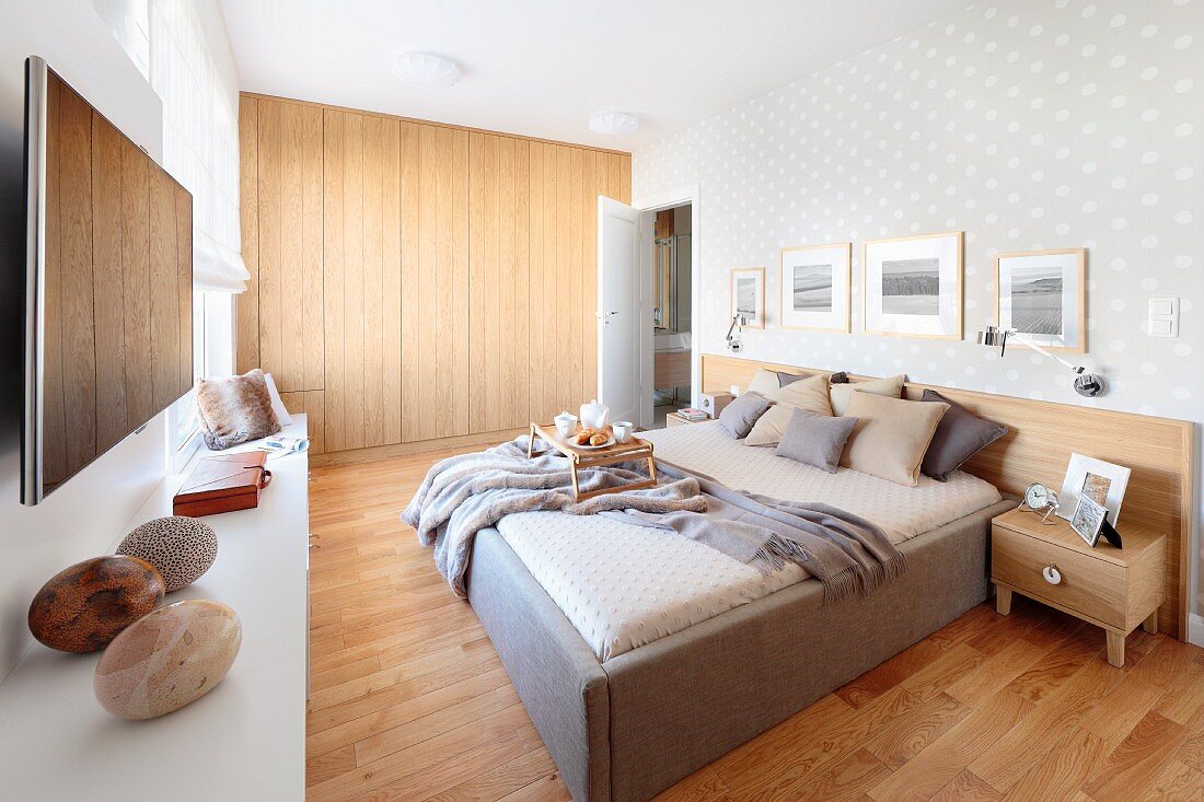 Schlafzimmer mit Doppelbett auf hellem Holzboden, im Hintergrund eingebauter, hermetischer Holzschrank