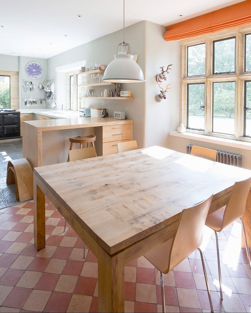 Massivholz Esstisch und moderne Stühle auf Vintage Schachbrettmusterboden in grossräumiger Küche
