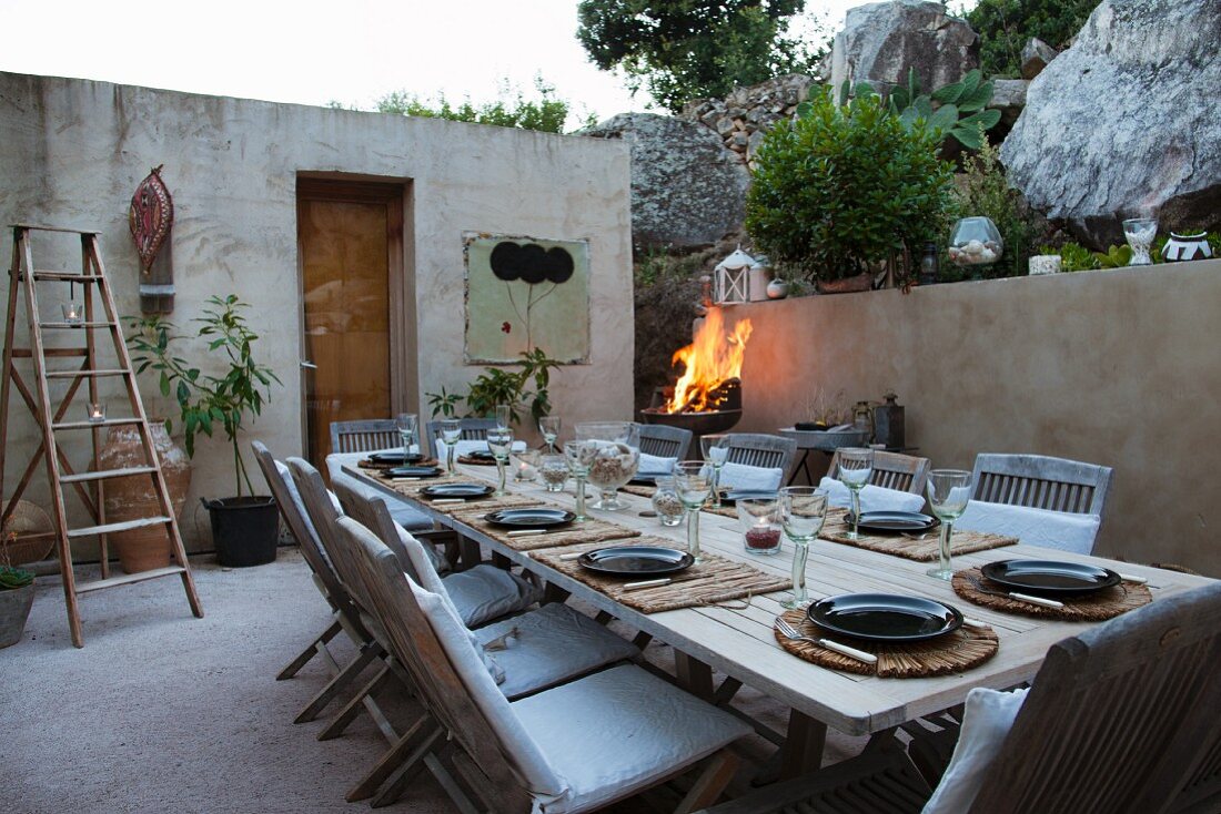 Innenhof eines mediterranen Bungalows mit gedecktem Tisch im Dämmerlicht