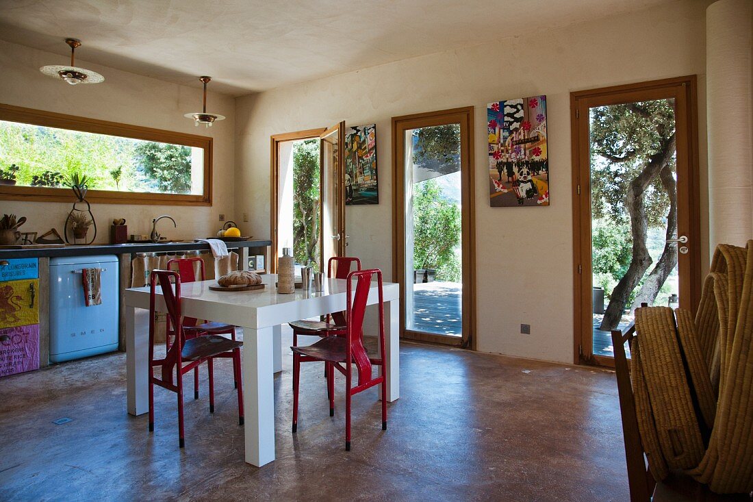 Eklektisch eingerichtete Küche mit Essbereich und Fenstern zur Terrasse