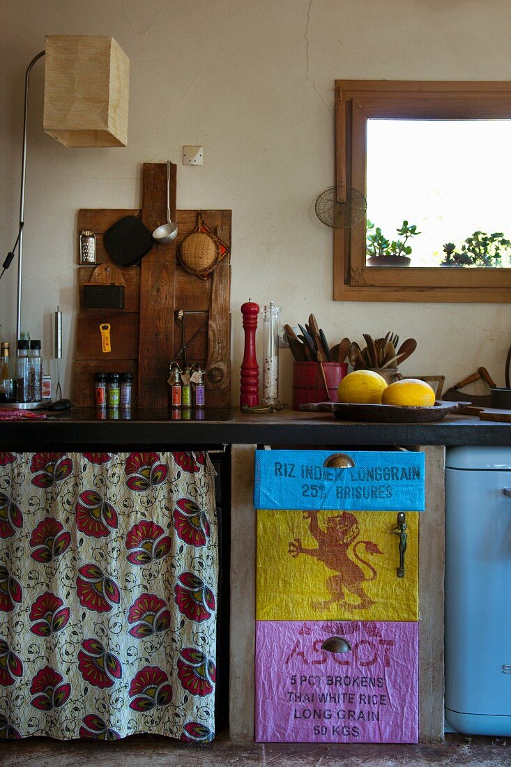 Individuelle Küchenzeile mit geblümtem Vorhang und alten Säcken gestaltete Fronten