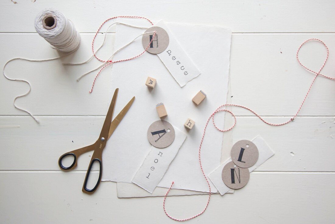 Making gift tags using paper, scissors, thread and stamps