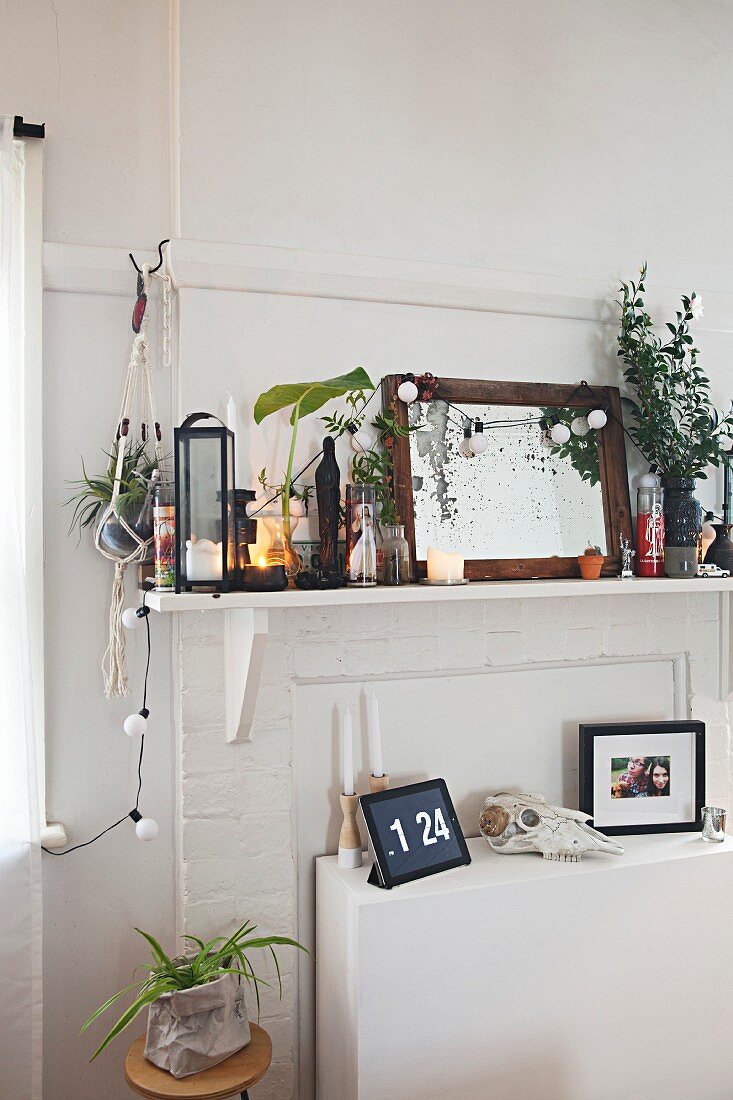 Shelf crammed with ornaments above white sideboard