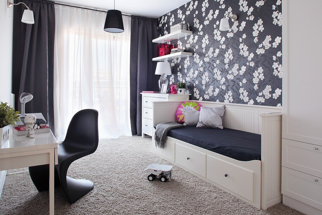 Schwarz-weiss gestaltetes Kinderzimmer mit floraler Tapete und Klassikerstuhl