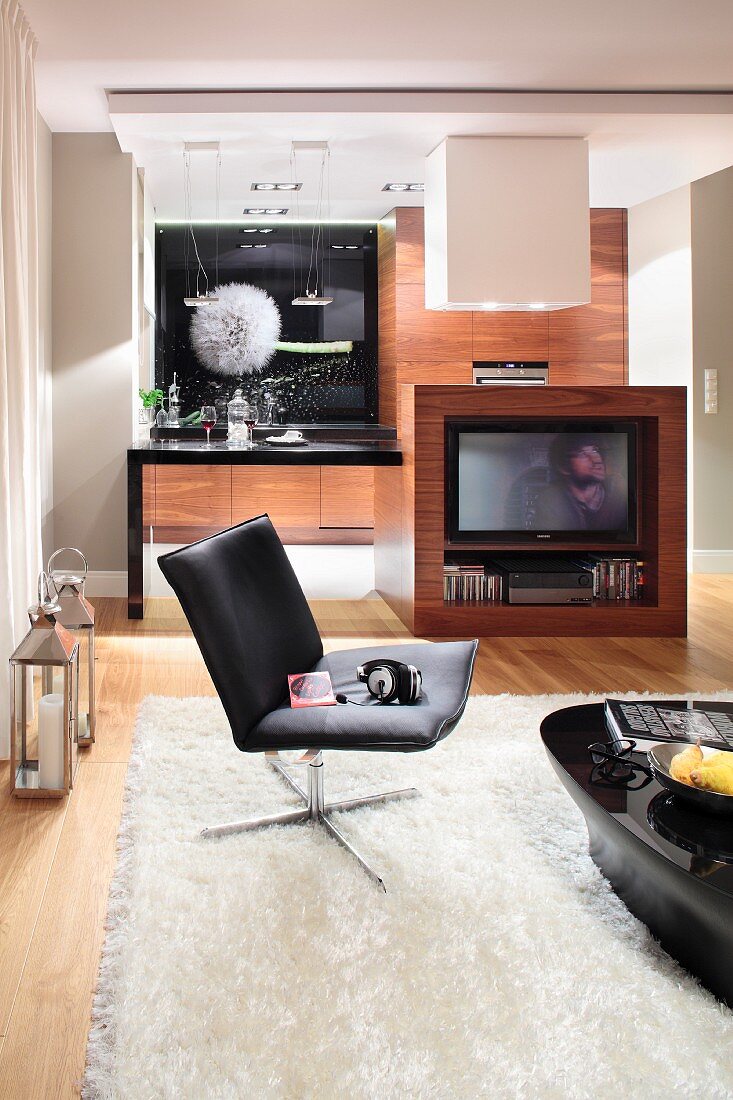 Wohnbereich mit Ledersessel und Hochglanztisch auf Teppich, Fernsehmöbel mit Edelholzfronten