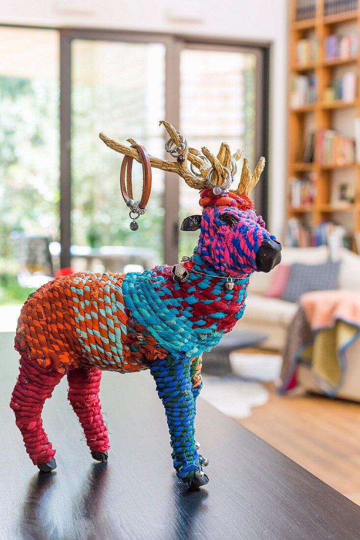 Künstlerische Tierfigur aus bunten Strickgarnen auf Ablage