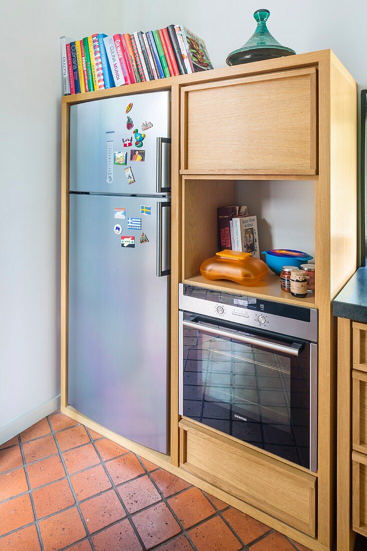 Küchenschrankelement aus hellem Holz mit integriertem Kühlschrank und Backofen