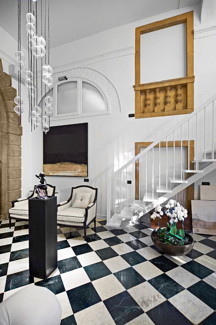 Elegantes Foyer mit Schachbrettmusterboden, oberhalb moderne Pendelleuchte
