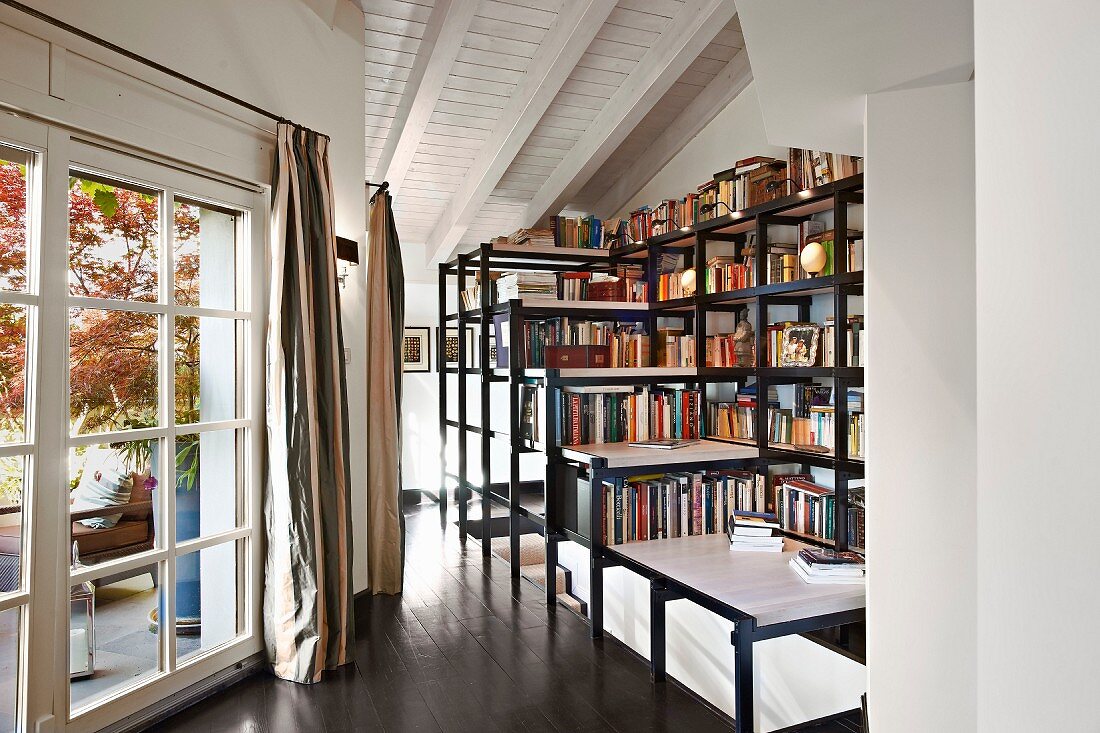 Large bookcases built over head of stairwell on landing