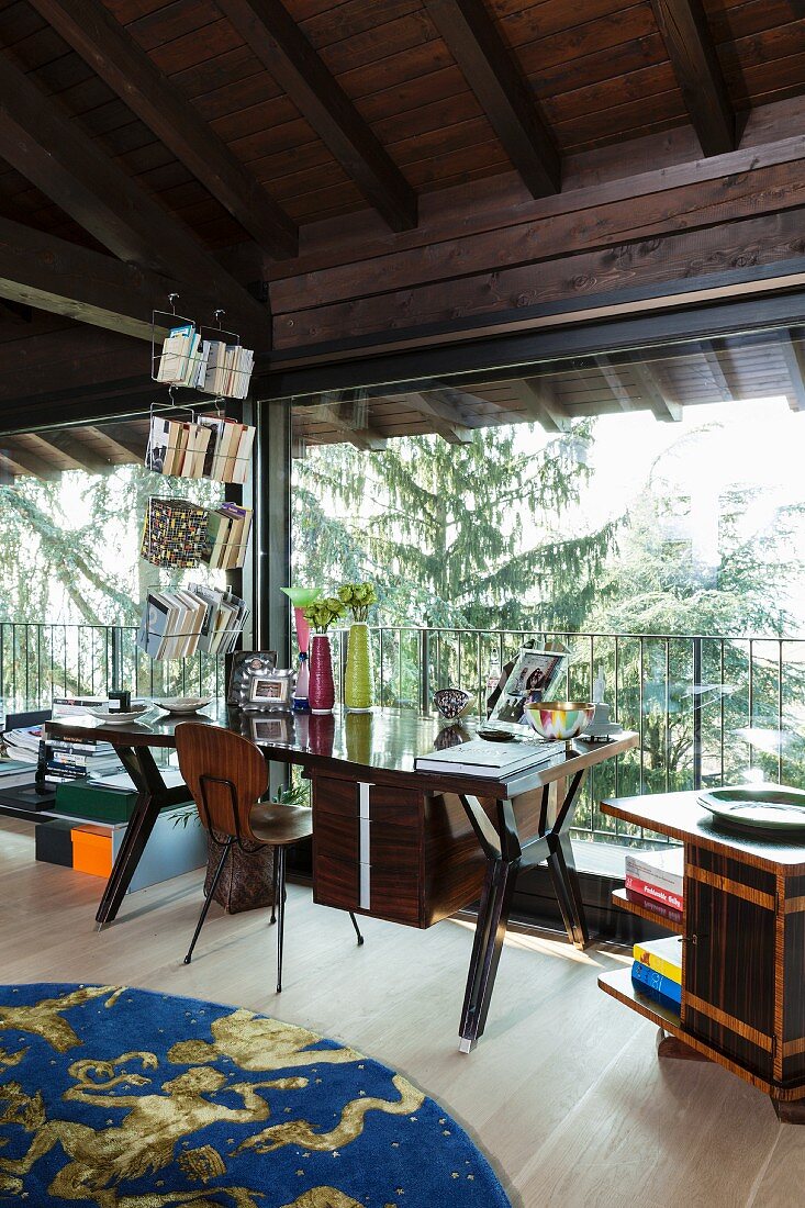 Retro Schreibtisch vor raumhohem Fenster mit Gartenblick in ausgebautem Dachgeschoss