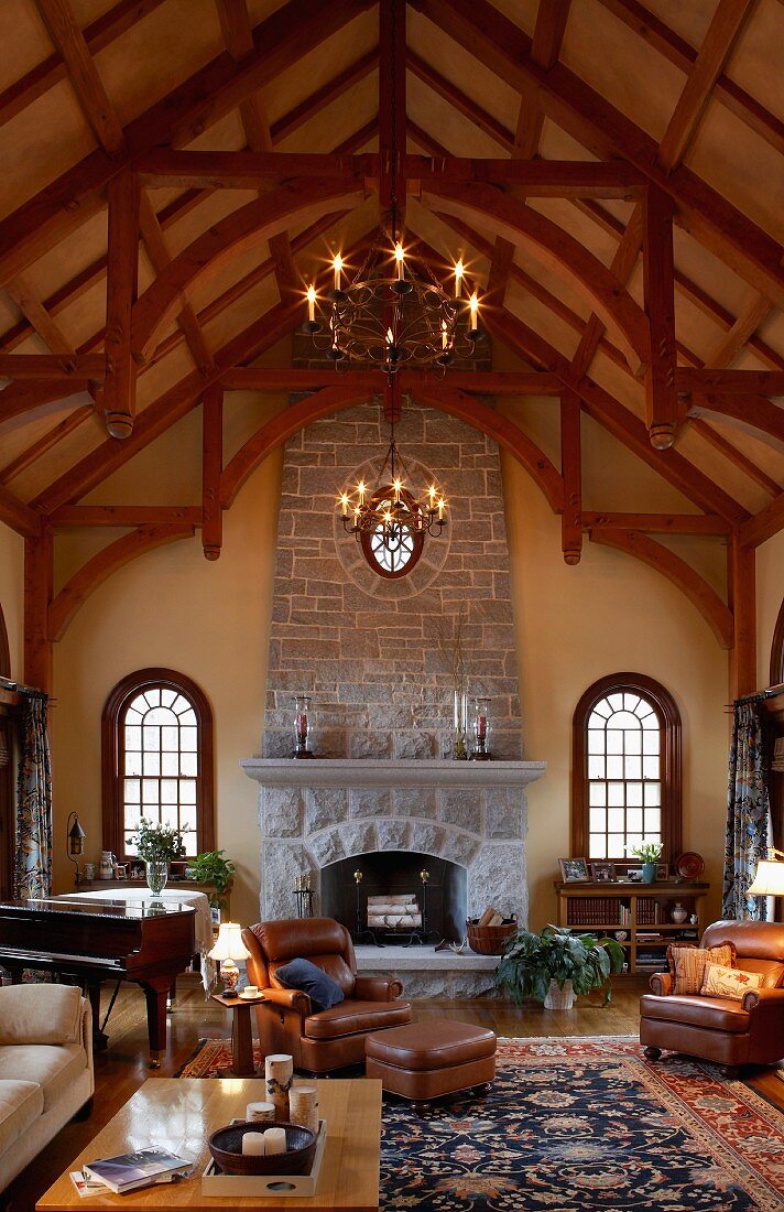 Grand, high-ceilinged, country-house interior with historical ambiance, stone fireplace and exposed rood structure