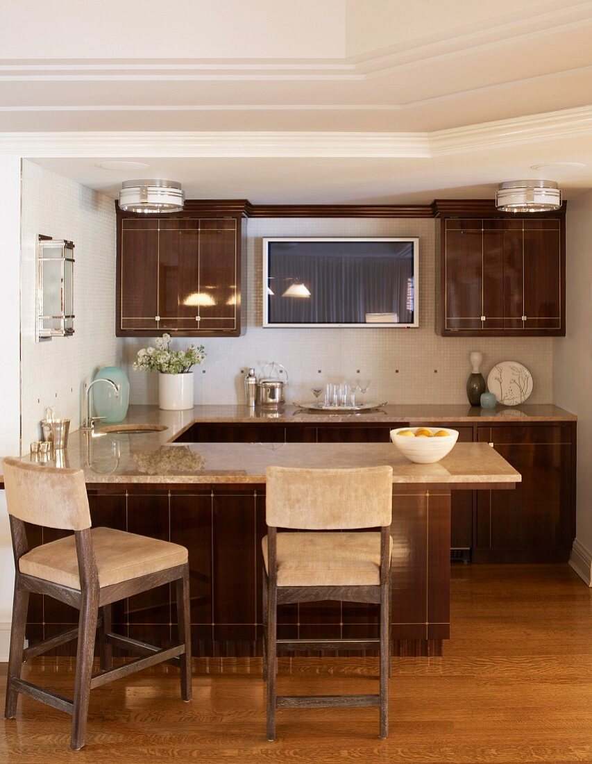 Country-house kitchen with glossy, brown fronts, breakfast bar and wall-mounted, flatscreen TV