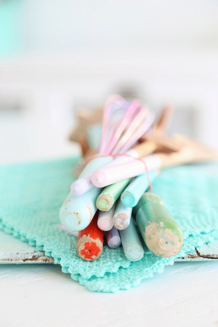 Pastel wooden spoons tied with rubber band on lacy turquoise doily