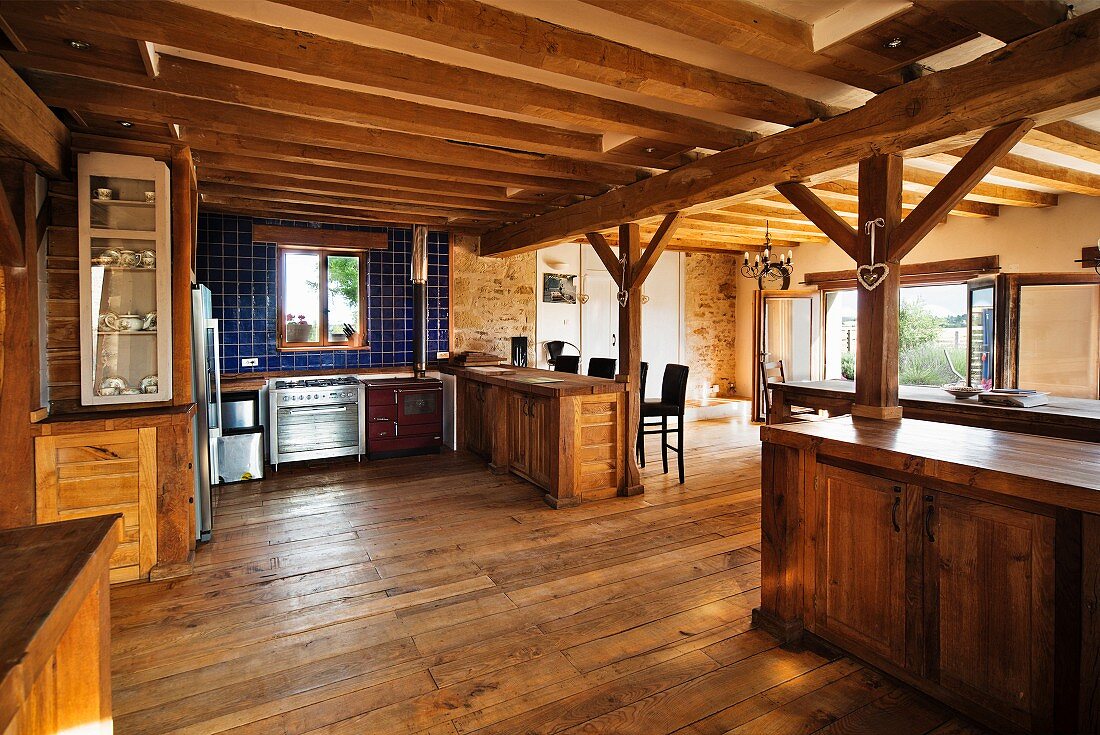 Grosszügige Landhausküche und Essbereich mit Holzbalkendecke und Holztragkonstruktion