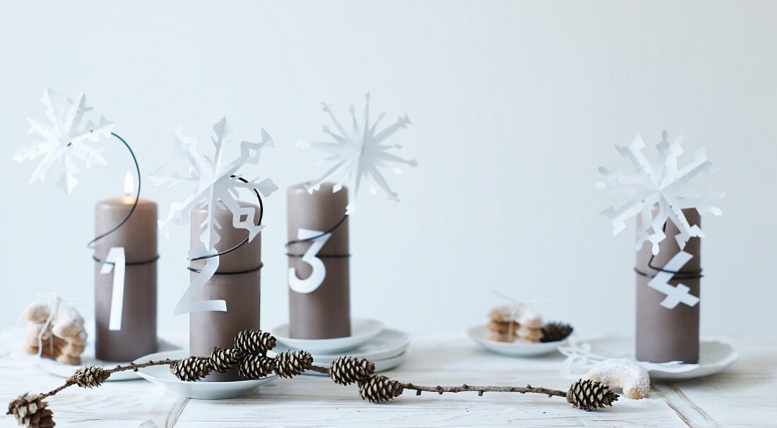 Paper snowflakes and letters on Advent pillar candles