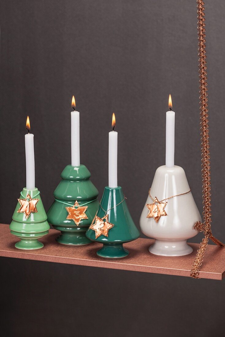 Weihnachtlicher Kerzenhänger aus kupferfarbenem Brett und vier Adventskerzen