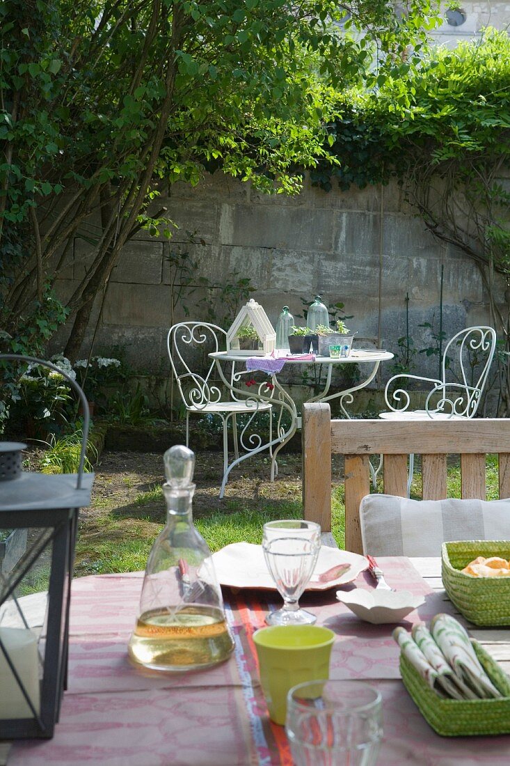 View over set table to ornate, metal garden furniture set
