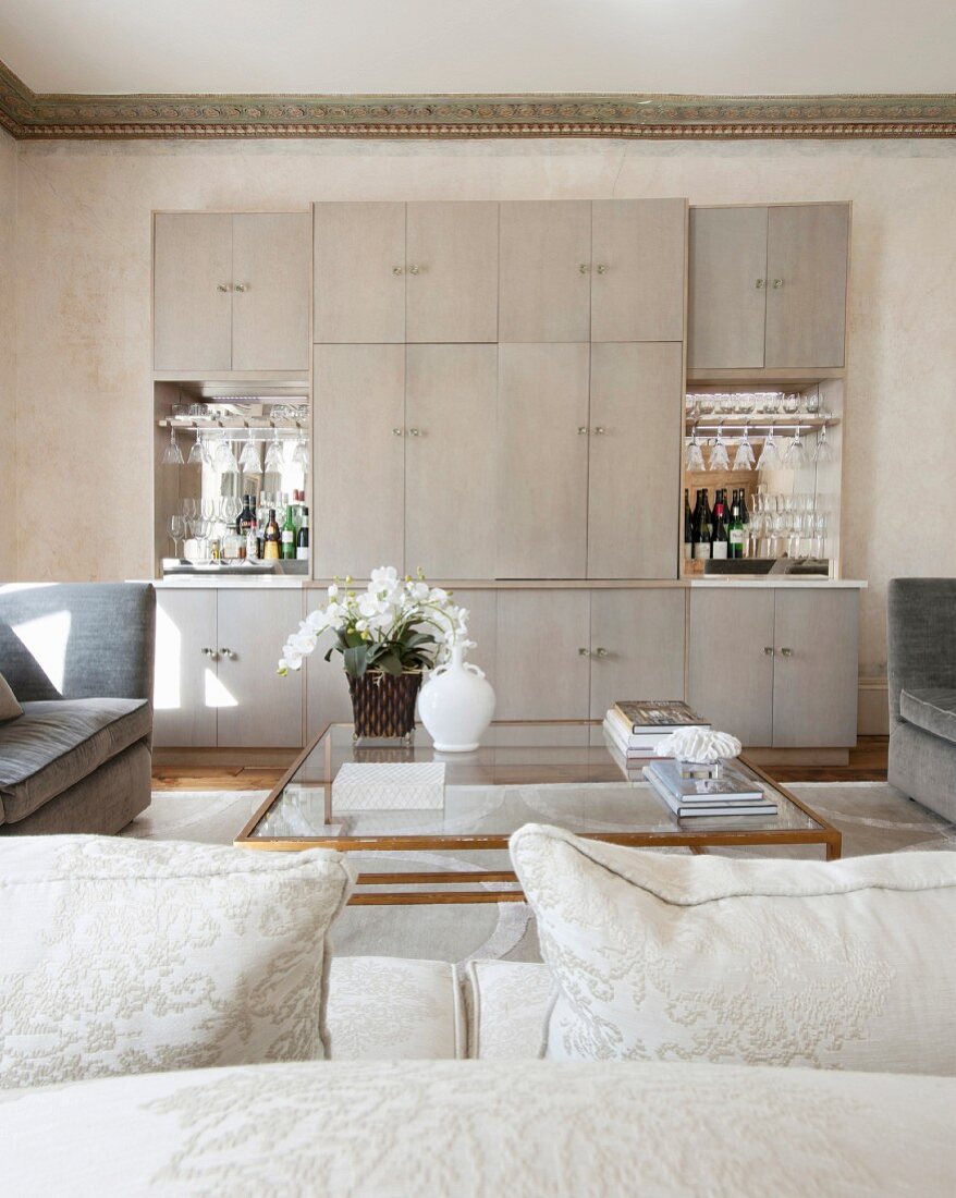 Blick über den Couchtisch auf schlichte Schrankwand mit zwei Bars in luxuriösem Wohnraum