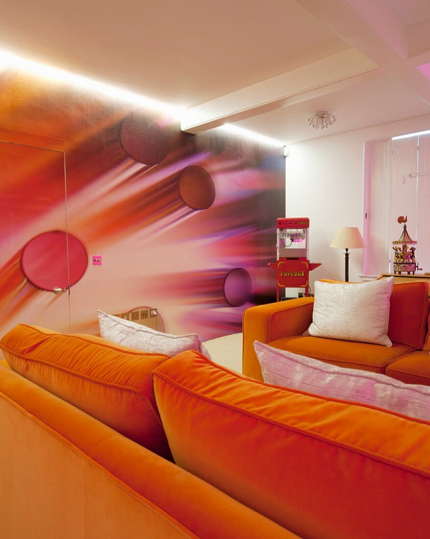 Two orange sofas in front of futuristic 3D wallpaper on wall and hidden door