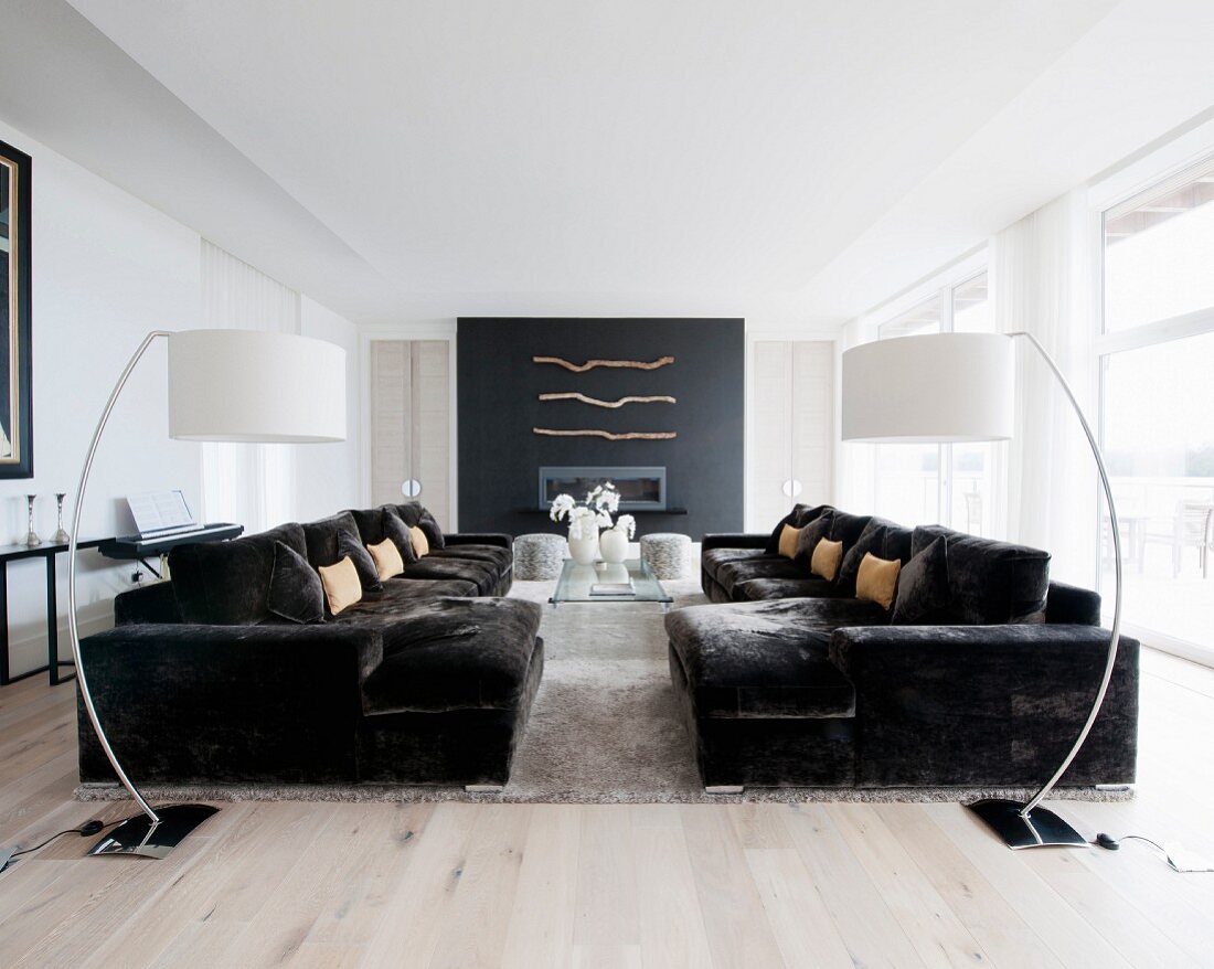 Symmetrisches Wohnzimmer mit gegenüberstehenden Sofas und Bogenlampen