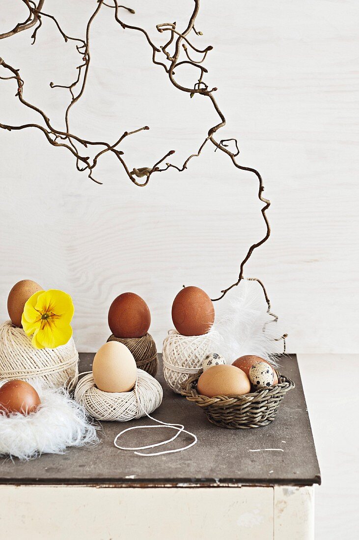 Balls of string, small, simple wicker basket and nest of feathers holding eggs