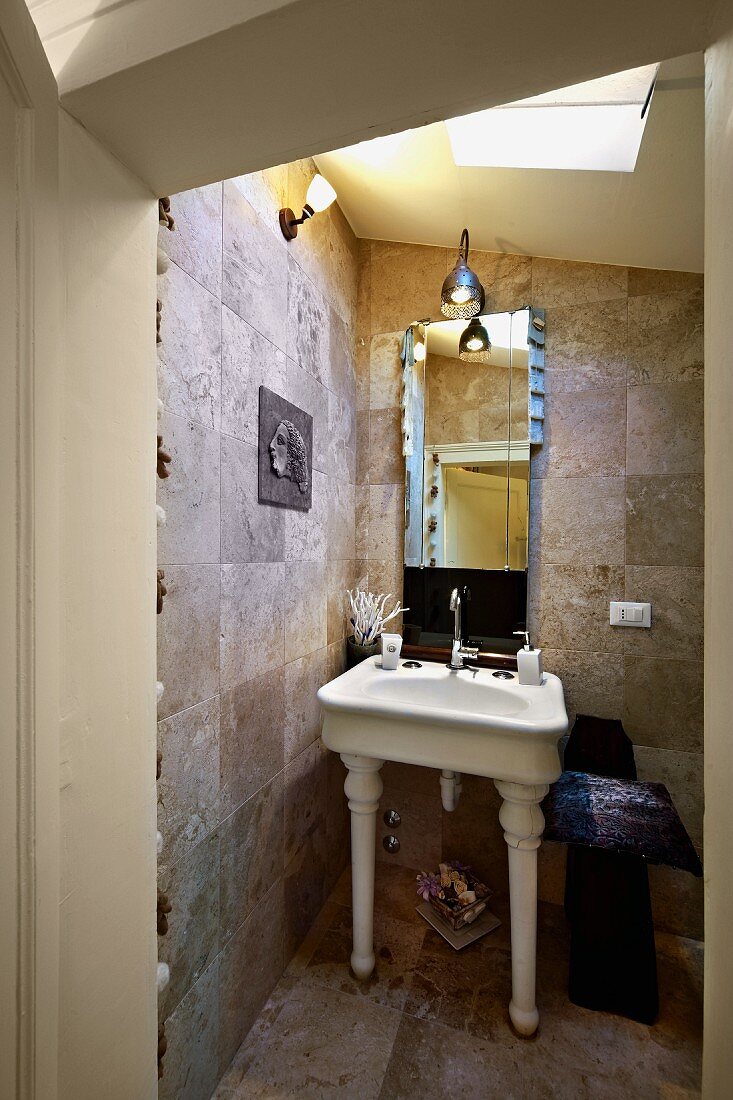 Blick durch offene Tür ins Bad mit weißem Vintage Standwaschbecken , Steinfliesen